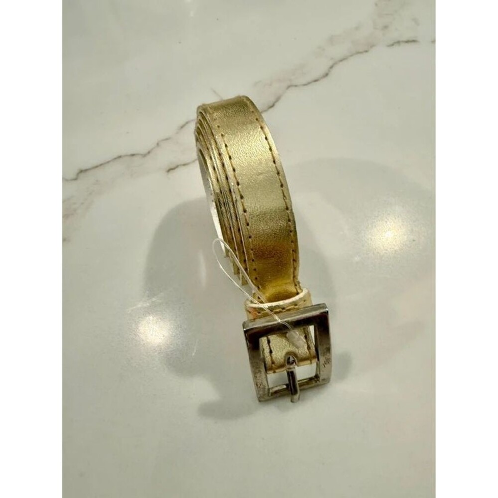 Gold metallic belt features a sleek rectangular buckle
